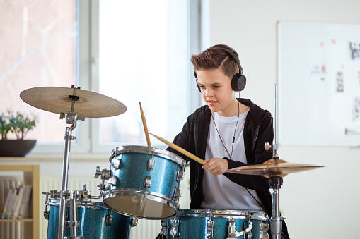 Student Playing Drums While Listening Music At Class Stock Photo - Download Image Now - iStock