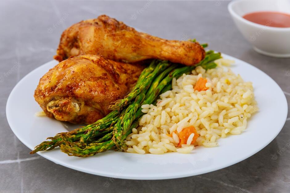 Premium Photo | Grilled chicken drumsticks with rice, asparagus and buffalo sauce.