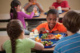 A group of children having lunch in a cafeteria | SNAP-Ed