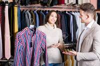 Happy European Female Shop Assistant Helping Customer To Choose Shirt In Men's Cloths Store Фотография, картинки, изображения и сток-фотография без роялти. Image 88763993.