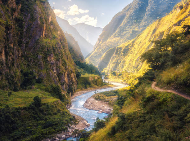 Colorful Landscape With High Himalayan Mountains Beautiful Curving River Green Forest Blue Sky With Clouds And Yellow Sunlight At Sunset In Summer In Nepal Mountain Valley Travel In Himalayas Stock Photo -