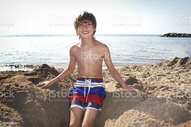 Boy Sitting In Hole He Dug At The Beach Stock Photo - Download Image Now - 8-9 Years, Beach, Blond Hair - iStock