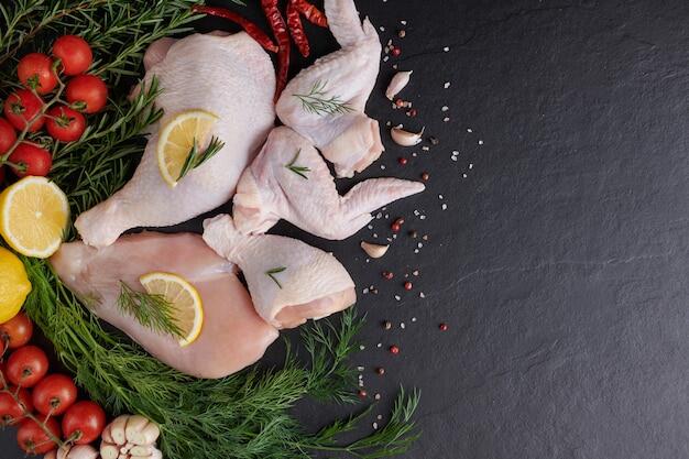 Бесплатное фото Сырое куриное филе с чесноком, перцем и розмарином на деревянной разделочной доске.